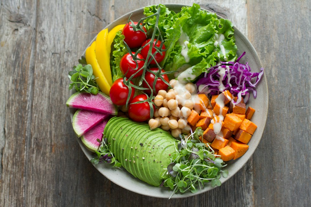 A colorful plate with vegetables, chickpeas, and avocado